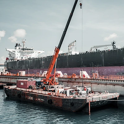 Two barges are docked to a dry dock on either side